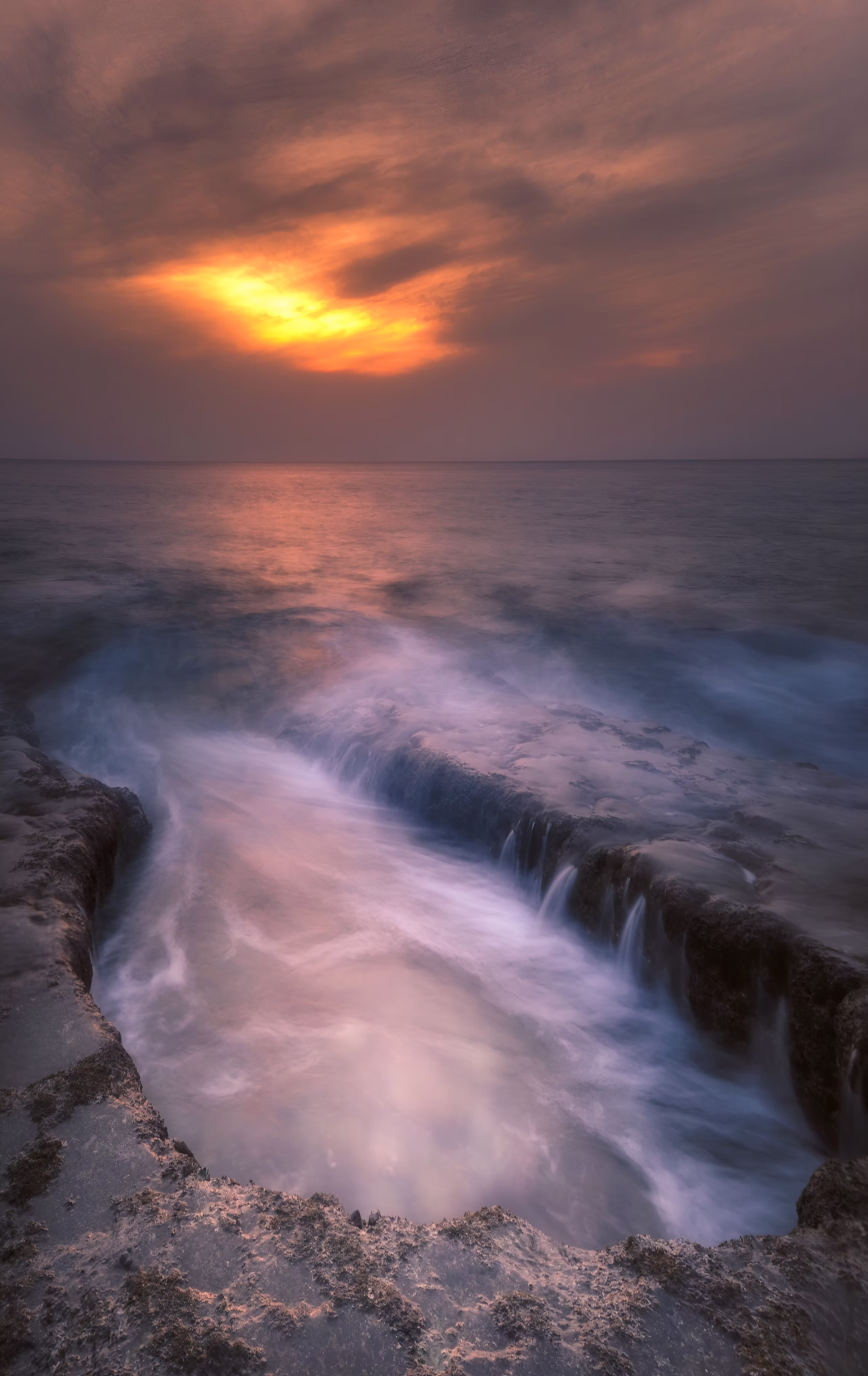 Long exposure of waves beneath a glowing Andaman sunset